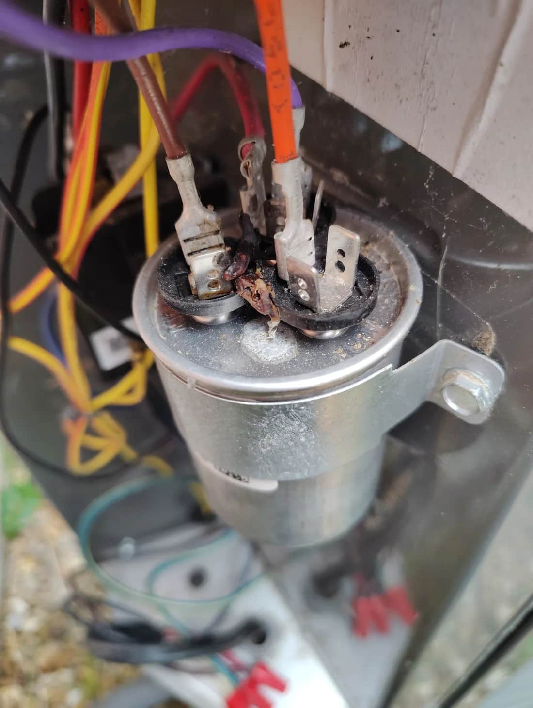 Visible heat damage at an HVAC capacitor terminal